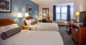 double queen bed hotel room with tv on dresser