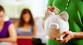 woman placing money into a piggy bank