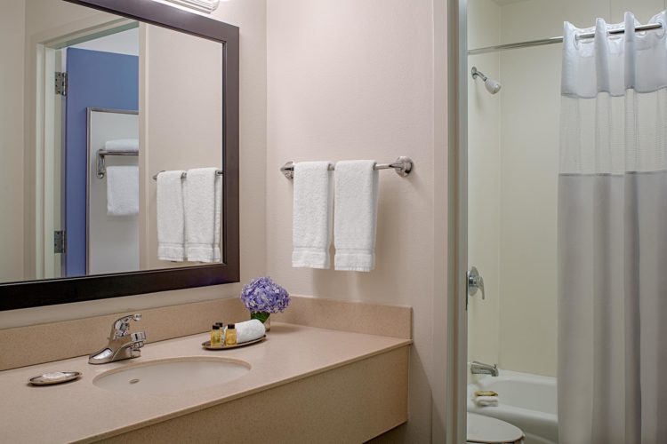 guest bathroom with large mirror over vanity